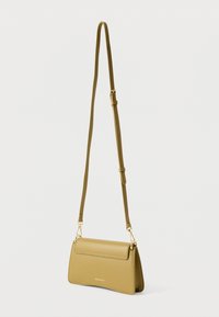 Mala de mão verde em couro com forma estruturada, fecho de aba magnética e alça ajustável. Apresenta relevo do logótipo na frente.