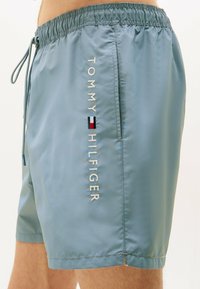 Herrenschwimmshorts in Hellblau, aus glattem, leichtem Material gefertigt. Verfügt über einen elastischen Bund und ein gesticktes Logo an der Seite.