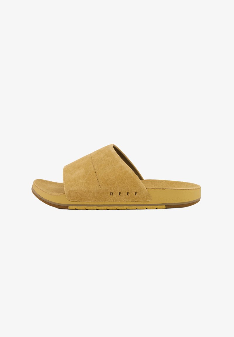 Light brown suede slide sandal with a cushioned footbed and rubber outsole. Features an open-toe design and prominent "REEF" branding.