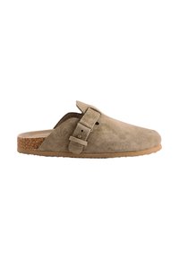 Beige suede slip-on clogs with a cork sole, adjustable buckle strap, and textured upper. Smooth finish with a rounded toe design.