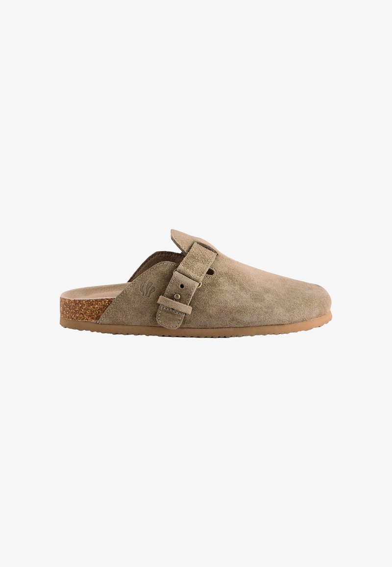 Beige suede slip-on clogs with a cork sole, adjustable buckle strap, and textured upper. Smooth finish with a rounded toe design.