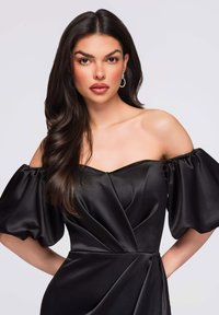 Robe noire épaules dénudées avec manches bouffantes, en satin lisse. Comprend un corsage ajusté avec un drapé subtil et des poches latérales.