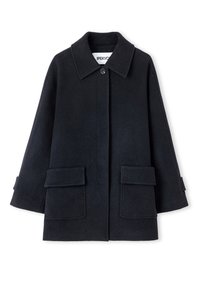 Cappotto nero in lana con colletto classico, chiusura frontale con bottoni e due grandi tasche applicate. Tessuto strutturato, vestibilità comoda e maniche a tre quarti.