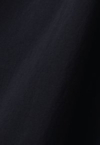 Texture de tissu noir avec un ombrage diagonal subtil et de fines nuances granuleuses dans des tons foncés.