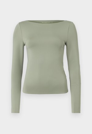 T-shirt à manches longues de couleur vert clair, avec un col rond et une silhouette ajustée en tissu lisse et extensible. Sans motifs ni embellissements.