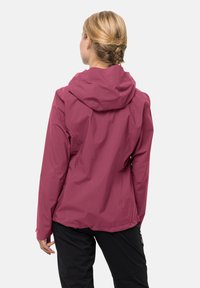 Pink, waterproof jacket with a hood; features a smooth texture and adjustable cuffs, worn with black pants. Back view shown.