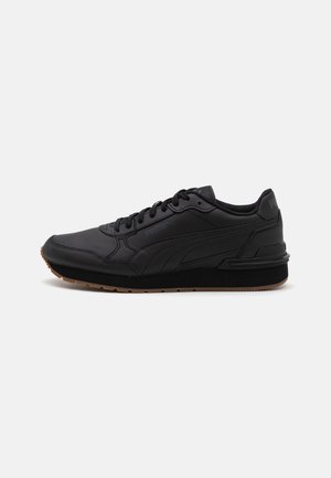 Zapatillas deportivas negras con parte superior de cuero liso, cuello acolchado y suela de goma negra. Presentan un sistema de cordones y detalles de marca sutiles.