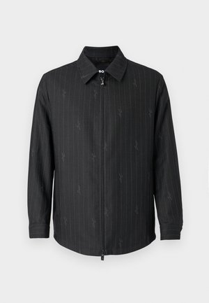 Black zip-up jacket with a collar, featuring subtle pinstripes and a textured fabric. Long sleeves with buttoned cuffs and a zipped front.