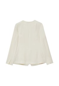 Blusa color crema a maniche lunghe con scollatura rotonda, dettagli di cucitura sul retro e spacchi sui lati dell'orlo per un movimento e una struttura aggiuntivi.
