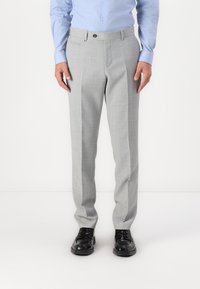 Pantalons cintrés gris clair avec un motif à carreaux subtils, devant plat et poches latérales, associés à des chaussures habillées noires.