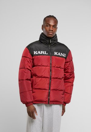 Chaqueta acolchada roja y negra con cuello alto, presenta los logotipos en blanco "KARL KANI" en el pecho; cuenta con cierre de cremallera y puños elásticos.