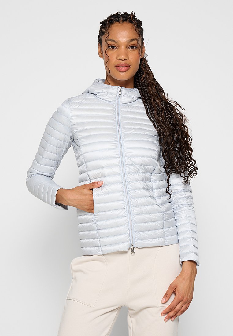 Giacca imbottita blu chiaro realizzata in tessuto trapuntato, con zip frontale, cappuccio e tasche laterali, caratterizzata da una texture liscia e lucida.