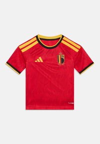 Crvena nogometna majica s uzorkom plamena, crnim ovratnikom i žutim detaljima, s grbom belgijske reprezentacije na prsima.