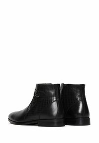 Botas de tobillo de cuero negro con un patrón texturizado similar al cocodrilo en los laterales. Cuentan con una cremallera lateral y un detalle de hebilla. Acabado suave.