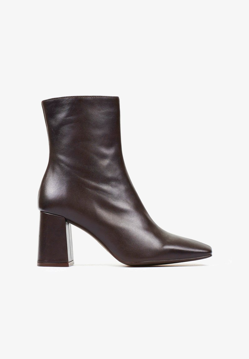 Brązowy skórzany botek do kostki z ostrym noskiem, gładką teksturą oraz masywnym blokowym obcasem z metalowym akcentem u podstawy.