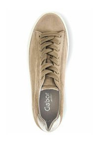 Beige suède sneaker met een ronde neus, voorzien van ton-sur-ton veters, een witte rubberen zool en een metallic accent op de teenkap.