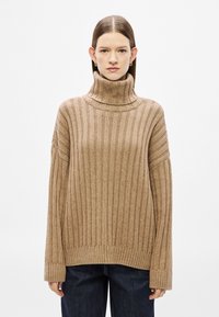 Μπεζ ριμπ πλεκτό πουλόβερ με ζιβάγκο, μακριά μανίκια, άνετη εφαρμογή και αντίθετο υφασμάτινο μοτίβο. Μαλακό πλεκτό υλικό με γιακά που διπλώνει.