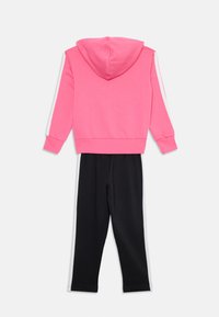 Haut à capuche rose avec capuche et pantalon noir avec rayures blanches sur le côté, fabriqué en tissu doux avec des poignets et une taille côtelés.