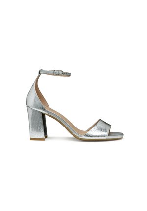 Sandal con tacco argentato con finitura metallica texturizzata, con punta aperta e cinturino alla caviglia. Presenta un tacco a blocco per maggiore stabilità.