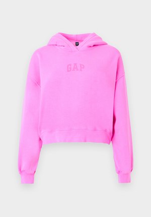 Sweat à capuche court rose vif avec manches longues et logo "GAP" sur le devant, avec une capuche et des poignets côtelés sur un fond uni.