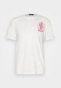 Camiseta de algodón blanca de manga corta, con un diseño gráfico rojo en el lado izquierdo del pecho, que incluye texto y un motivo de serpiente.