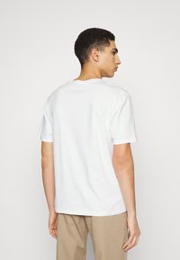 Witte katoenen t-shirt met ronde hals en korte mouwen, met een eenvoudig ontwerp zonder zichtbare patronen of accenten.