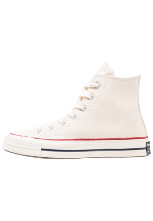 Högsneaker i off-white canvas med kontrasterande röda och marinblå ränder på sulan, silverfärgade öglor och klassisk gummitå.