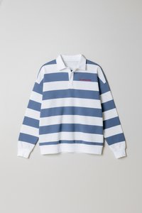 Μπλε και λευκό ριγωτό πουλόβερ με γιακά, με κόκκινα γράμματα. Κατασκευασμένο από απαλό ύφασμα, έχει μακριά μανίκια και χαλαρή εφαρμογή.