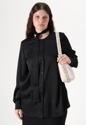 Black satin blouse with a button-down front, long sleeves, and a tied neck. Includes a cream handbag with a textured finish and patterned strap.