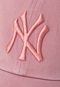 Roza bejzbolska kapica ima teksturirano blago, zakrivljen rez in vezeno NY logo u usklađenoj roza nijansi.