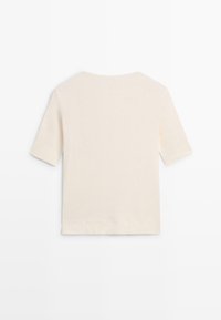 Chemise à manches courtes de couleur crème avec un col rond, vue de dos sur un fond blanc uni.