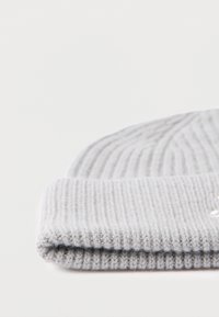 Grå ribstrikket hue med foldet skygge. Teksturen er blød og hyggelig med subtil syning og et minimalistisk design.