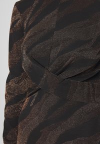 Schwarzer Stoff mit bronzefarbenem Tigermuster, mit weicher Textur, subtiler Schimmer und einem Wickeldetail in der Taille.