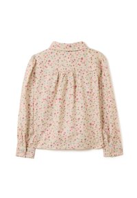 Camicia floreale a maniche lunghe color crema con piccoli fiori rosa, blu e verdi. Presenta un colletto e polsini abbottonati, con uno sfondo arricciato.