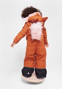 Tuta da neve imbottito arancione con accenti in pelliccia sintetica rosa e un design sul retro giocoso. Presenta pannelli neri sulle gambe e una base con motivo viola e bianco.