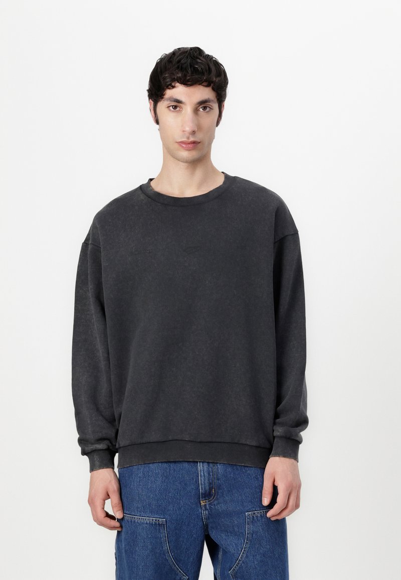 Dark gray sweatshirt with a crew neckline, loose fit, and ribbed cuffs and hem. Made from soft fabric with a slightly faded texture.