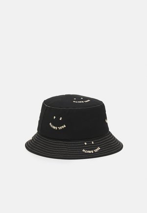Sort bucket-hat med hvide smiley-ansigter og "Paul Smith" tekst broderet omkring kronen og skyggen.