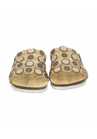Kork-Sandalen mit einem hellbraunen Grundton, kreisförmigen Ausschnitten und dunkeln braunen Akzenten. Flache weiße Sohle für Komfort.