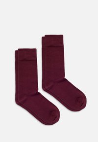 Calzini bordeaux realizzati in un tessuto liscio, con un polsino a coste e un design della punta senza cuciture per comfort e durata.