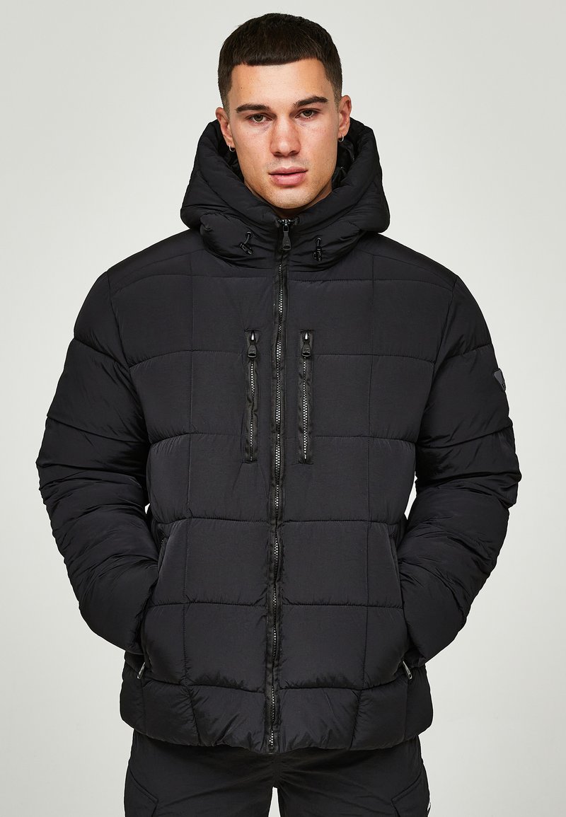 Schwarze Steppjacke mit Kapuze, mit einem quadratischen Steppmuster, zwei vorderen Reißverschlusstaschen und schwarzen Reißverschlüssen. Hergestellt aus glattem, leichtem Material.
