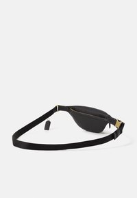 Czarna skórzana torba na ramię o gładkiej fakturze, zakrzywionym kształcie, z zamkiem błyskawicznym i złotym metalowym zapięciem. W zestawie regulowany czarny pasek.