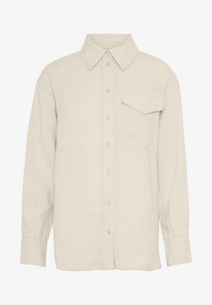 Šviesiai smėlinės ilgomis rankovėmis marškiniai, pagaminti iš lino. Turi smailų apykaklę, sagų priekyje ir krūtinės kišenę kairėje pusėje.