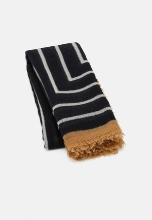 Écharpe noire rectangulaire avec des lignes géométriques blanches et des bords à franges brunes, pliée sur un fond blanc.