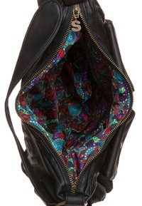 Bolso de mano de cuero negro con un interior estampado que presenta diseños florales en rojo, azul y verde. Incluye cremallera dorada y detalles de herrajes en tono oro.