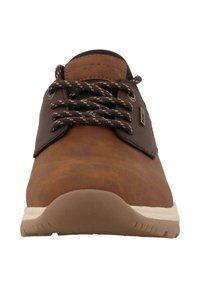 Hnědá kožená bota s texturovaným povrchem, dekorativním stehem a tmavými tkaničkami. Obsahuje gumovou podrážku s polstrovanou základnou.