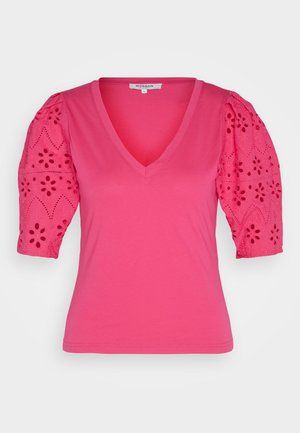 Roza majica s V-izrezom in kratkimi napihnjenimi rokavi. Rokavi imajo cvetlični vezni vzorec. Mehka tkanina; oprijet kroj.