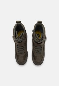 Tmavě zelené vysoké tenisky vyrobené z semišového a síťovinového materiálu, s šněrováním a zipovým zapínáním, texturovanými detaily a robustní podrážkou.