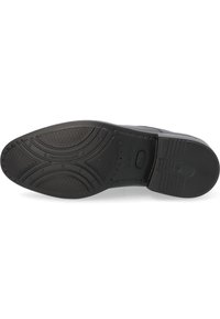 Suela de zapato de goma negra con patrones texturizados, que presenta una puntera redonda y elementos de tracción elevados. Incluye detalles de la marca cerca del talón.