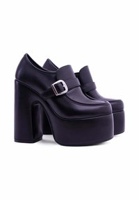 Scarpe platform nere realizzate in pelle liscia, con un ampio tacco a blocco, punta rotonda e una fascia decorativa con una fibbia argentata.