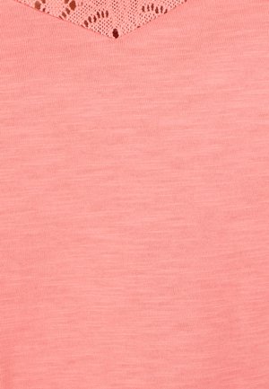 Tela rosa suave con textura de punto fino y un delicado detalle de encaje triangular en el borde superior.